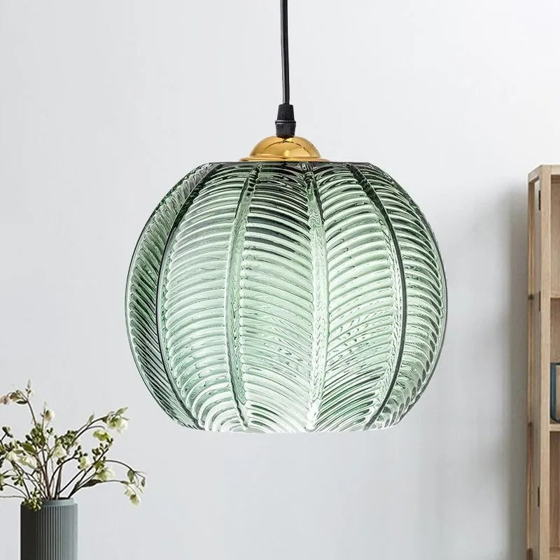 The Clérachic Ribbed Green Glass Pendant Light in a bright living corner beside an oak shelf, daylight picking out every moulded rib.