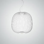 The wide, rounded wire-cage Clérachic pendant in white on a pale grey backdrop, its lit base visible below.