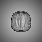 The wide, rounded wire-cage Clérachic pendant in black against a grey backdrop, with a lit base underneath.