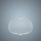 The low, wide drum-shaped wire-cage Clérachic pendant in white, on a pale blue-grey backdrop.