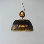 Front view of the Clérachic ribbed smoked-glass pendant, its black adjustable cord looping down to the brass-topped finial.