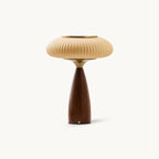 This Clérachic ribbed table lamp on a plain white backdrop, a wide cinnamon shade with a brass top over a tapered walnut-colour base.