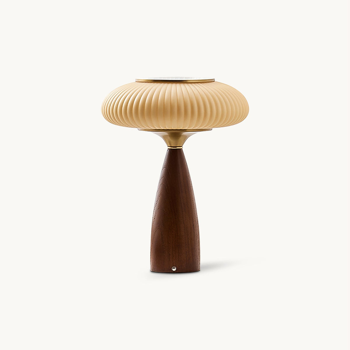 This Clérachic ribbed table lamp on a plain white backdrop, a wide cinnamon shade with a brass top over a tapered walnut-colour base.