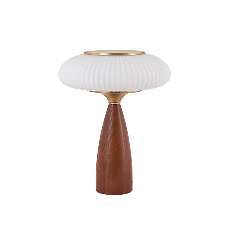 This Clérachic ribbed table lamp with a white shade on a white backdrop, a brass top over a tapered walnut-colour base.