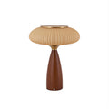 This Clérachic ribbed table lamp with a cinnamon shade on a white backdrop, a brass top over a tapered walnut-colour base.