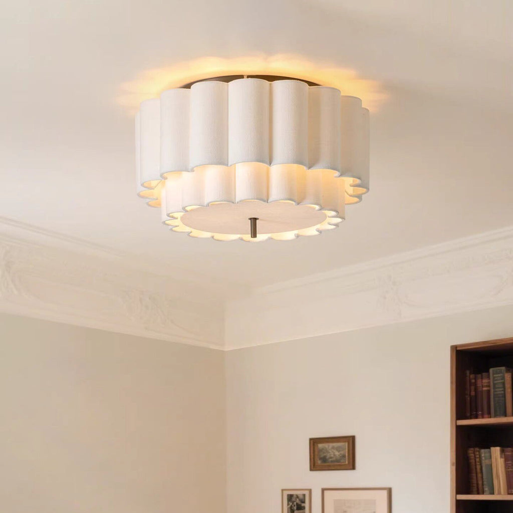 Lit on a ceiling above panelled mouldings, this Clérachic ceiling light throws a warm halo of light around its ribbed white fabric shade.