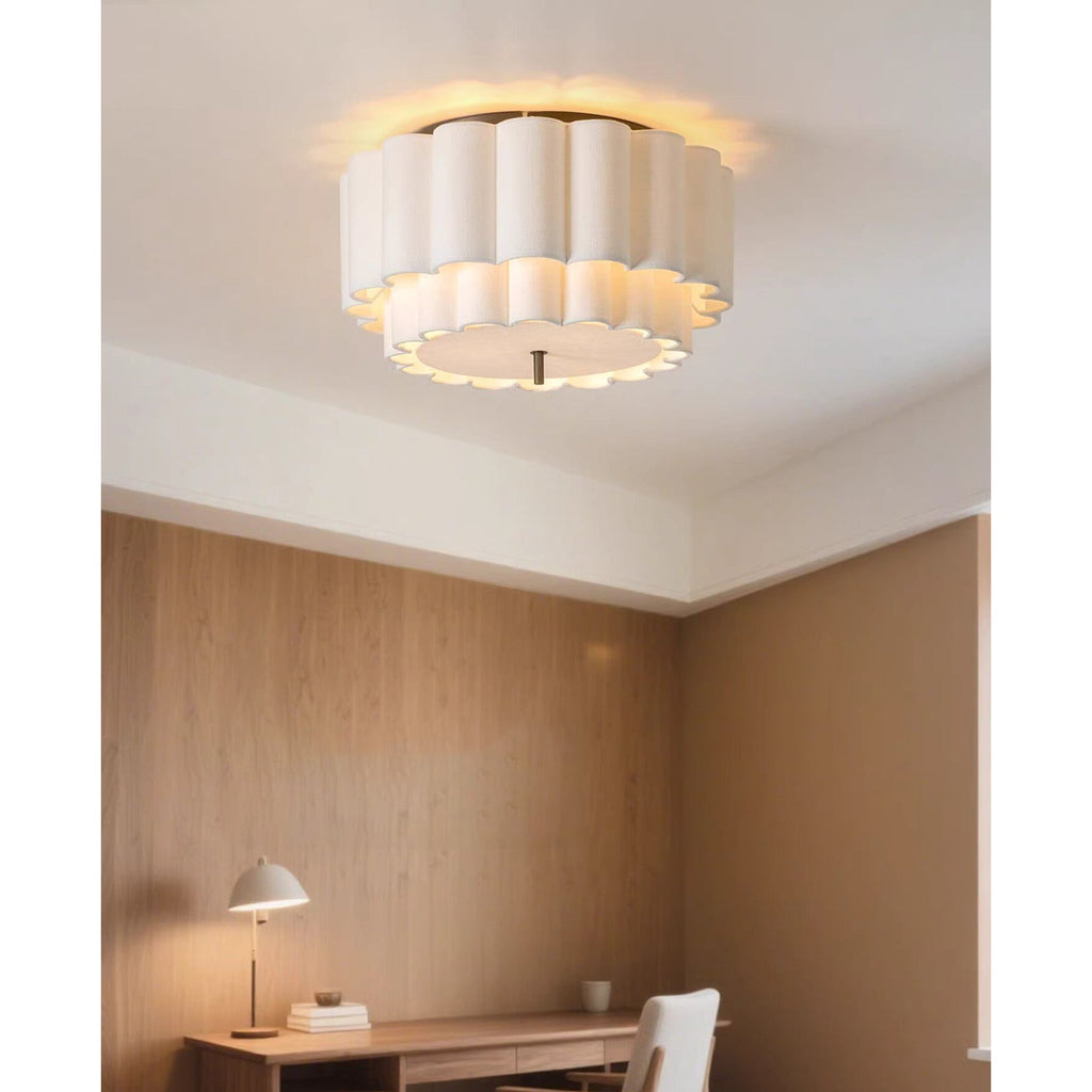 A Clérachic ceiling light lit in a room with oak-panelled walls, a wooden desk and a small table lamp in the distance.