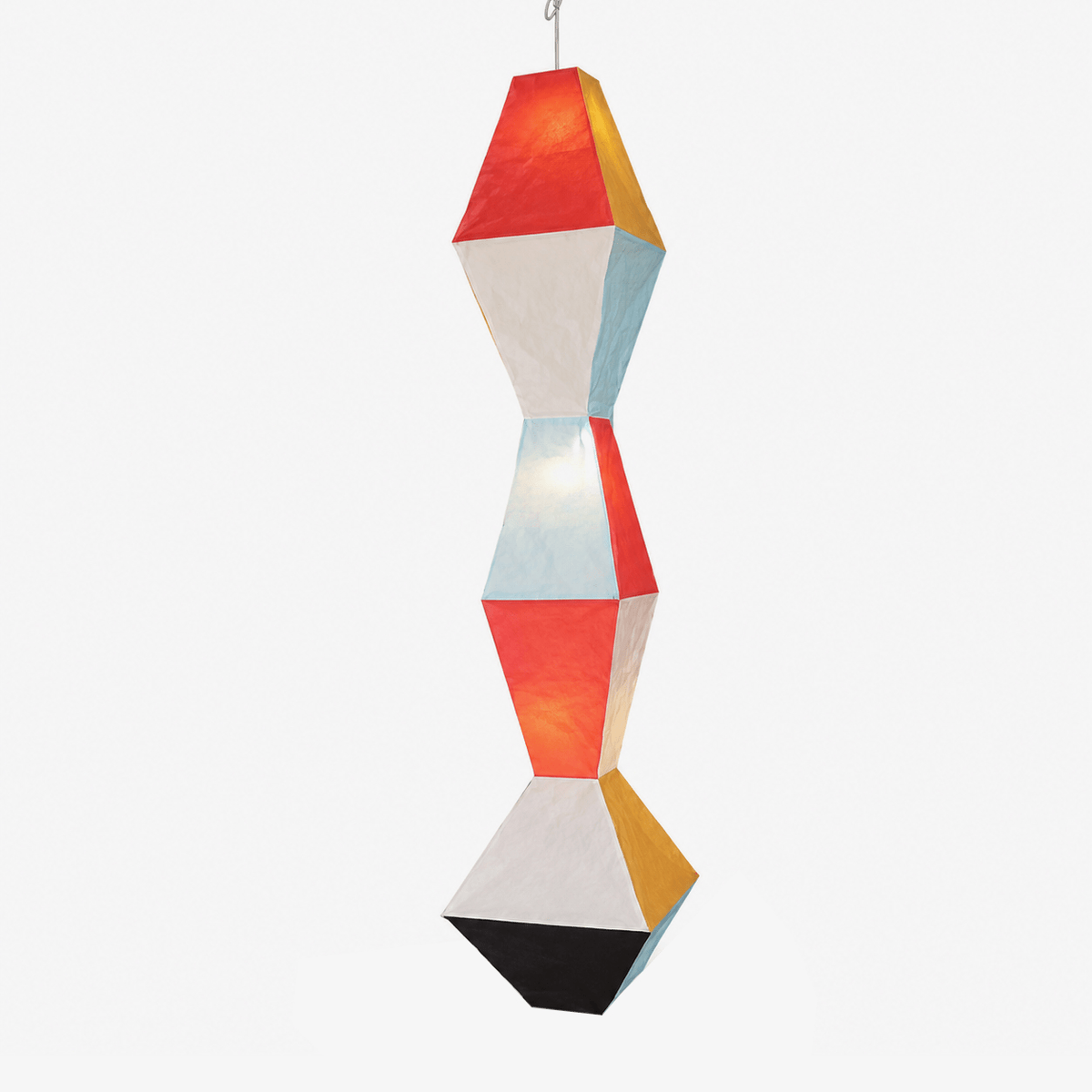 Clérachic stacked geometric rice paper pendant lamp photographed alone against a white background, its painted red, mustard and blue facets alternating with unpainted cream paper above a matte black base.