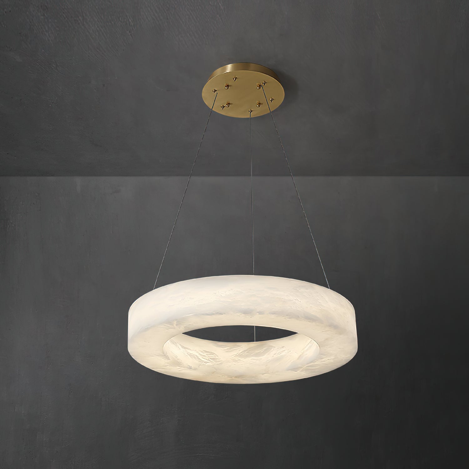 Clérachic alabaster ring chandelier lit from within, suspended on fine cables from a brushed brass canopy.
