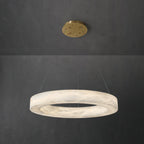 The Clérachic chandelier hung short from a brass canopy, warm light pooling inside the alabaster ring.