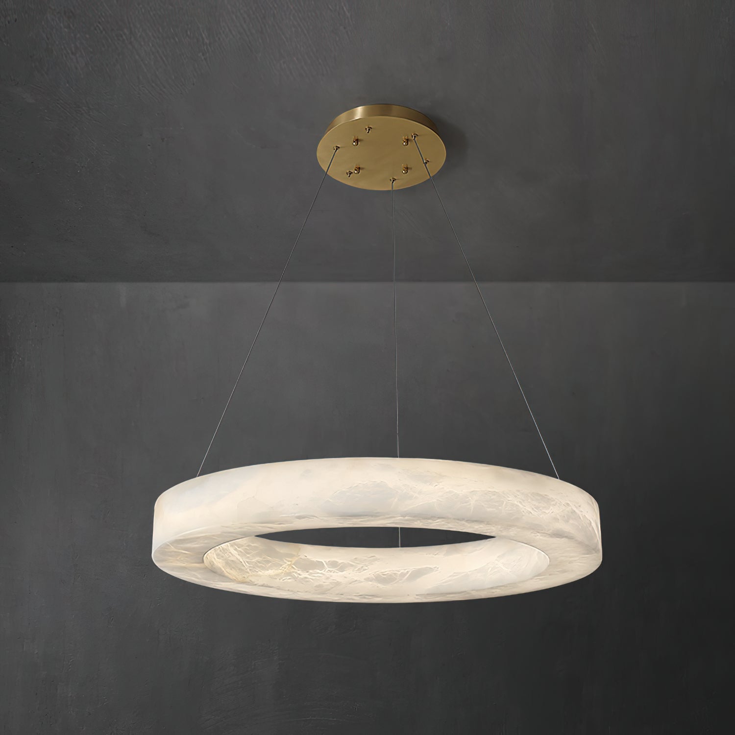 The Clérachic chandelier hung short from a brass canopy, warm light pooling inside the alabaster ring.