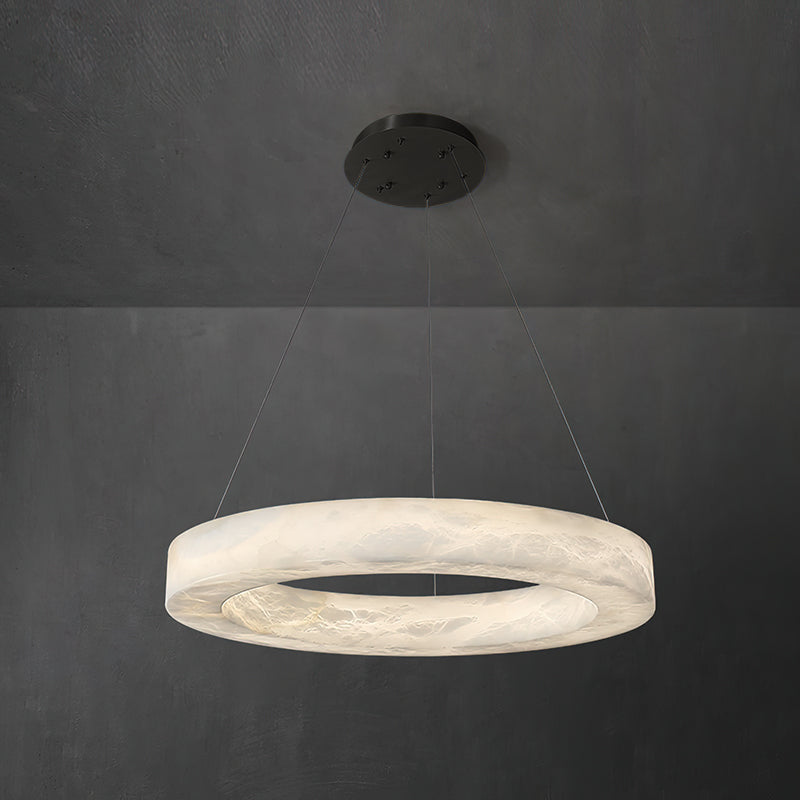 The Clérachic chandelier with a deep alabaster band, hung on a black canopy against a concrete-grey wall.