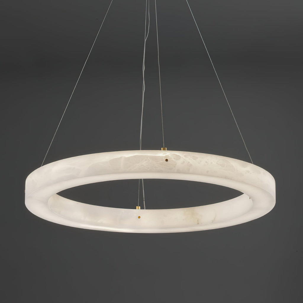The Clérachic chandelier seen from directly below, brass cable clamps spaced evenly around the alabaster hoop.