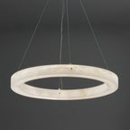 The Clérachic chandelier seen from directly below, brass cable clamps spaced evenly around the alabaster hoop.