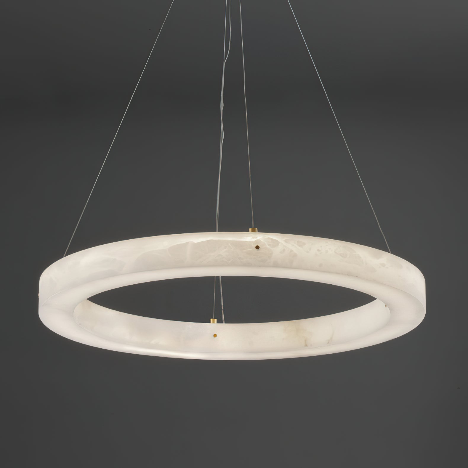 The Clérachic chandelier seen from directly below, brass cable clamps spaced evenly around the alabaster hoop.