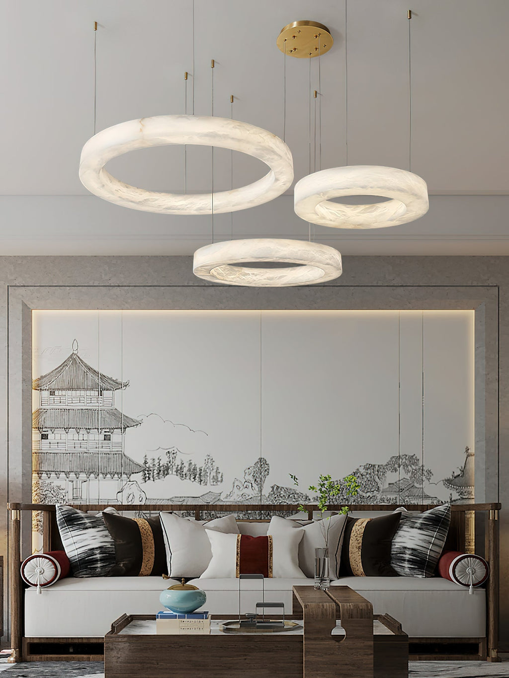 The Clérachic three-ring chandelier above a seating group, hoops staggered in front of a painted screen.