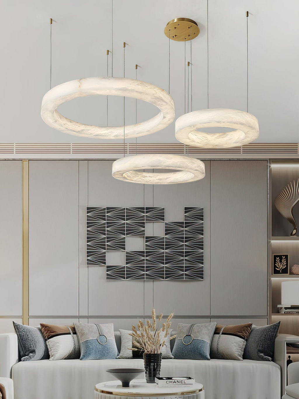Clérachic three-ring chandelier lighting a living room, tiered hoops set against graphic wall art.
