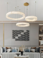 Clérachic three-ring chandelier lighting a living room, tiered hoops set against graphic wall art.