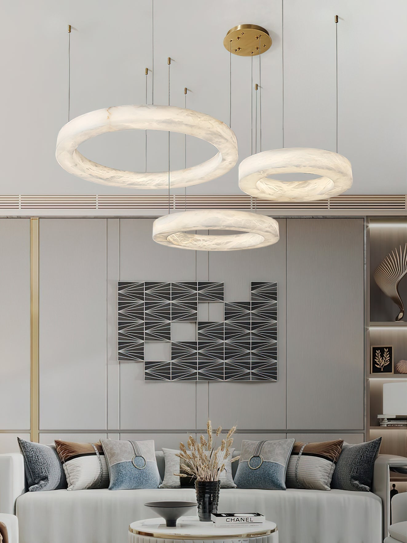 Clérachic three-ring chandelier lighting a living room, tiered hoops set against graphic wall art.