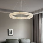 The Clérachic ring chandelier in a furnished sitting room, warm light spilling down over a green sofa.