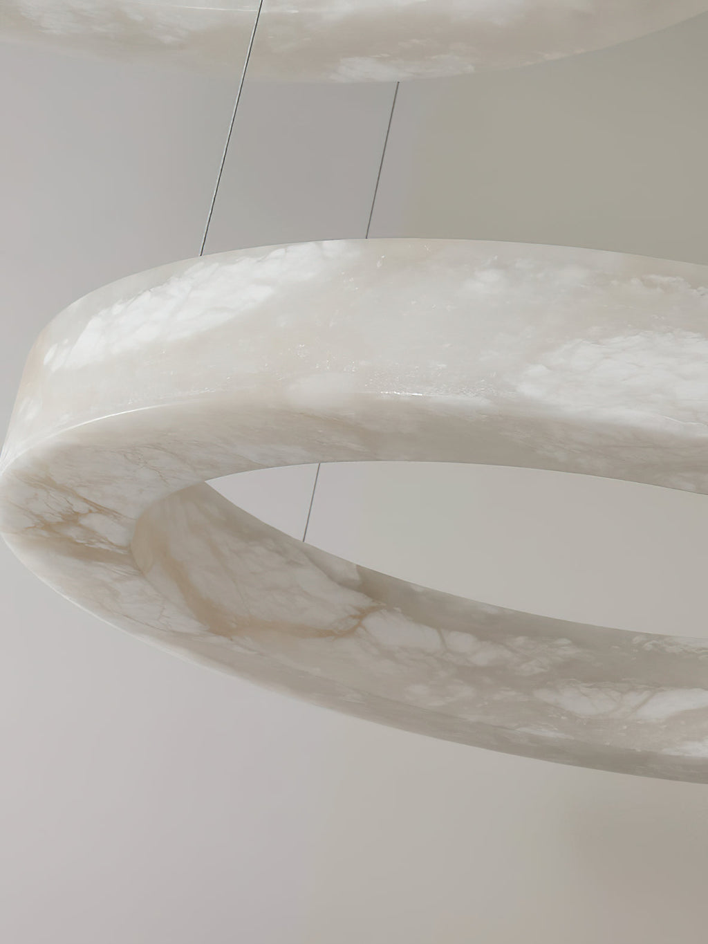 Close detail of the Clérachic alabaster ring, the stone's translucent grey veining lit from inside.