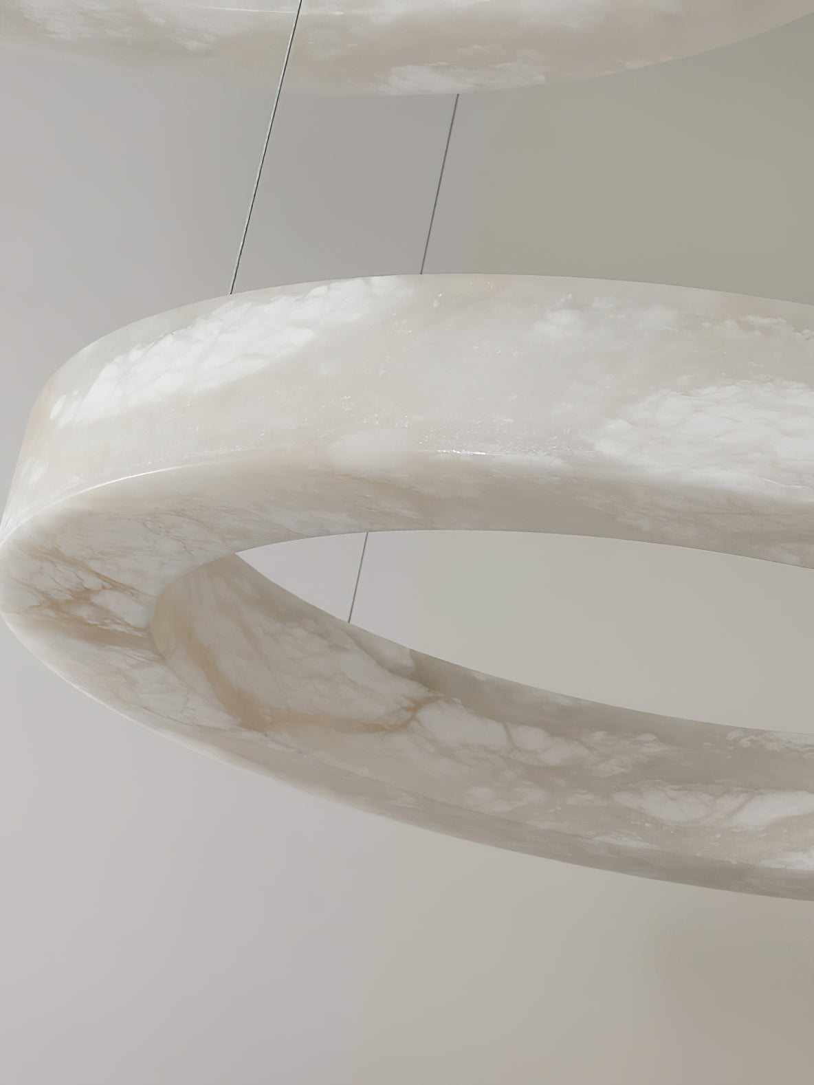 Close detail of the Clérachic alabaster ring, the stone's translucent grey veining lit from inside.