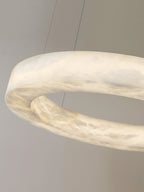 The Clérachic ring in close-up at an angle, the alabaster band glowing amber where the stone is thinnest.