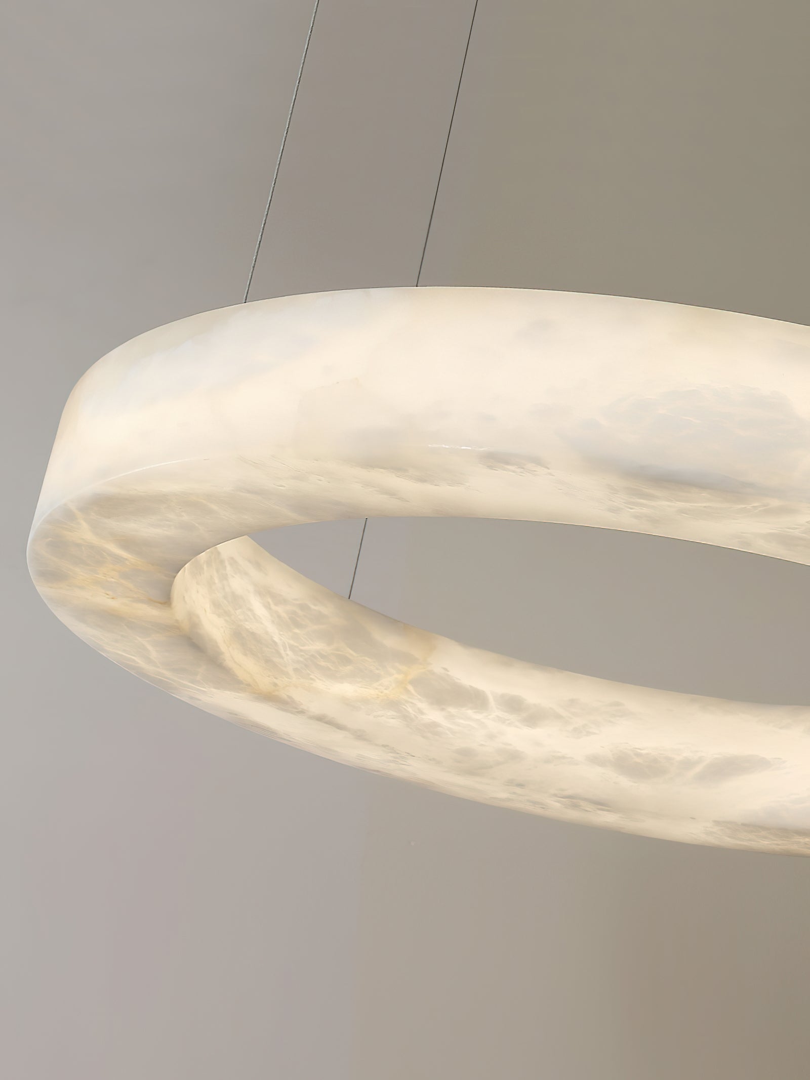 The Clérachic ring in close-up at an angle, the alabaster band glowing amber where the stone is thinnest.