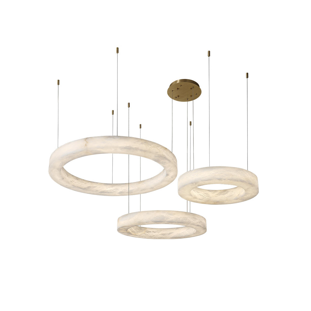 The Clérachic three-ring chandelier on a plain white ground, brass canopy above three alabaster hoops.