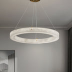 The Clérachic chandelier hung from a brass canopy in a soft grey room, the alabaster ring lit end to end.