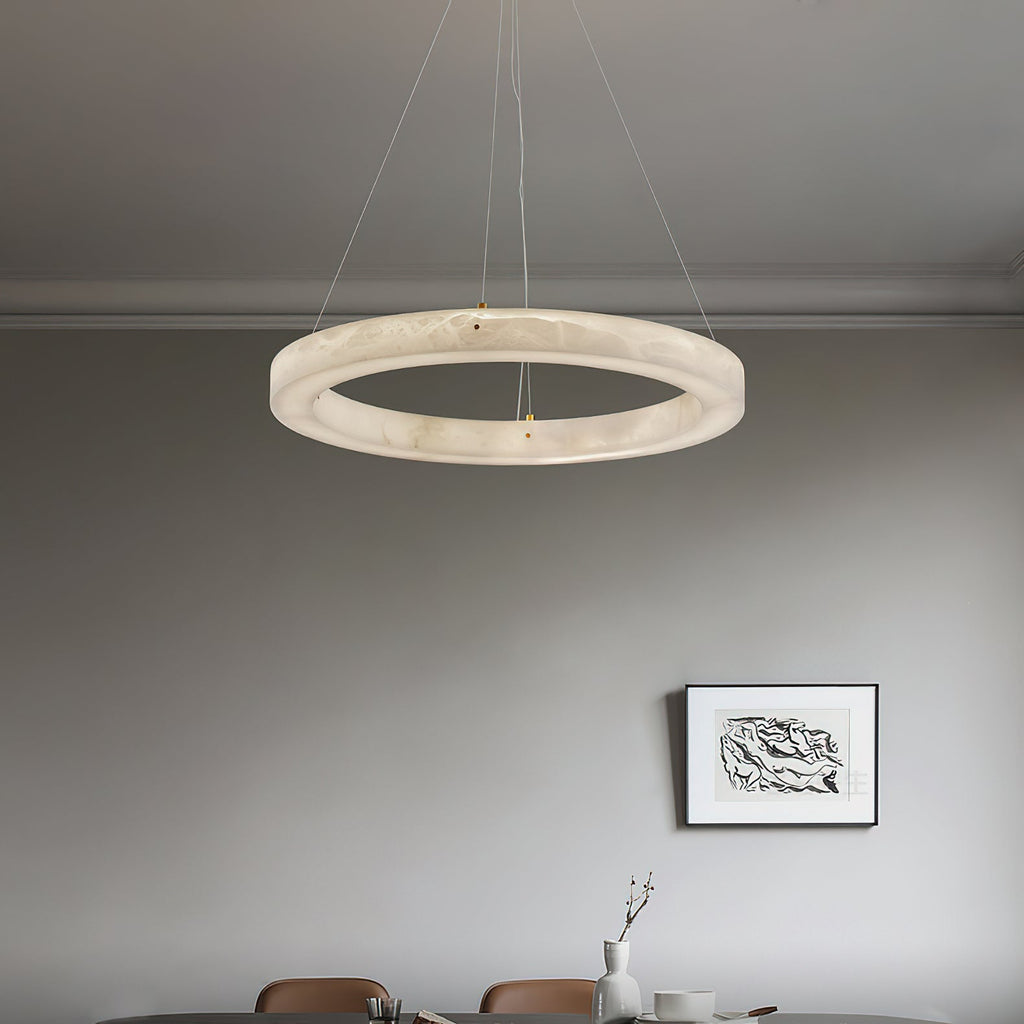 Clérachic ring chandelier centred over a dining table, its warm band of alabaster light framing the setting.