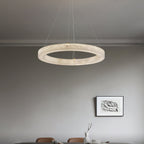 Clérachic ring chandelier centred over a dining table, its warm band of alabaster light framing the setting.