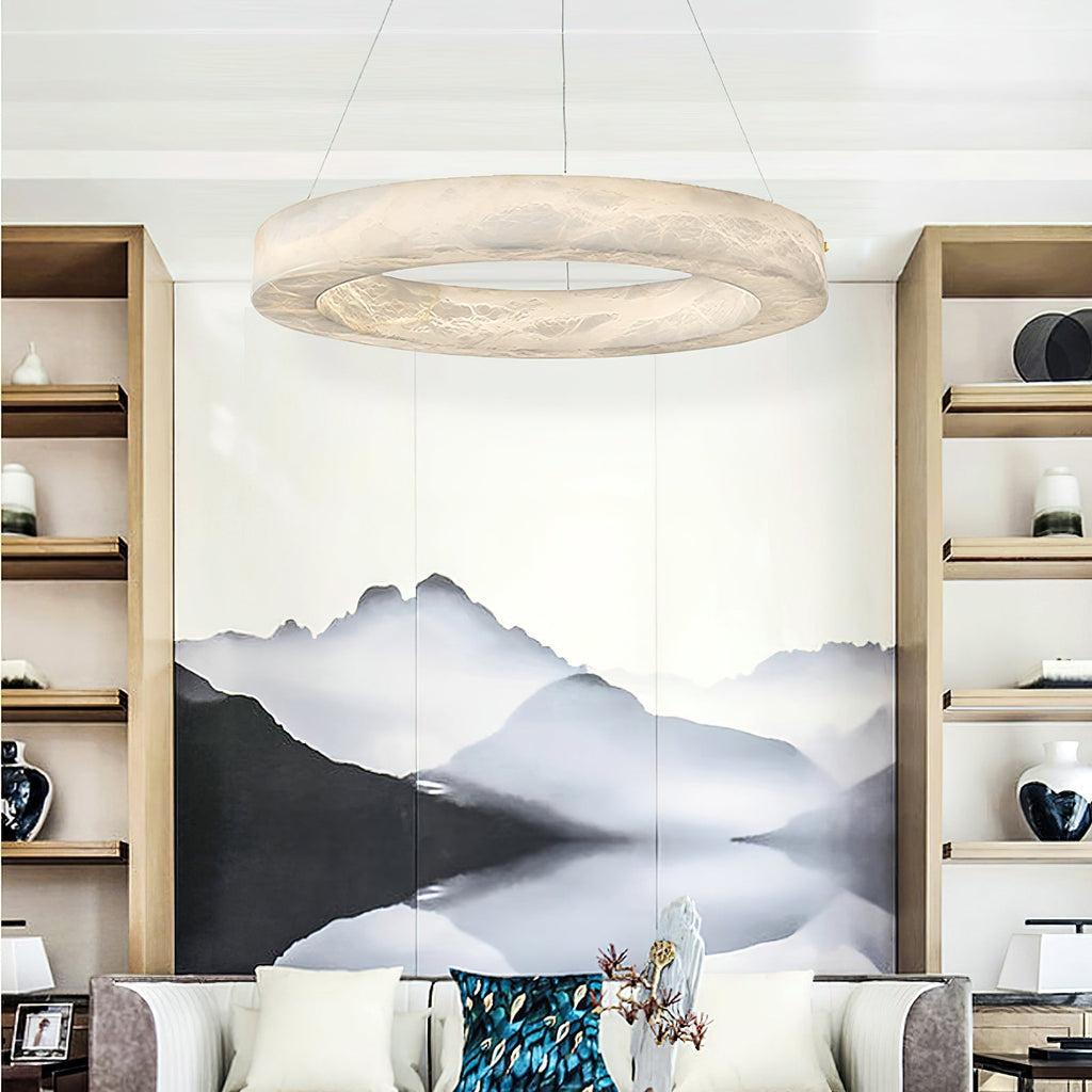 The Clérachic chandelier above a living room with a mountain mural, the ring glowing between tall shelves.
