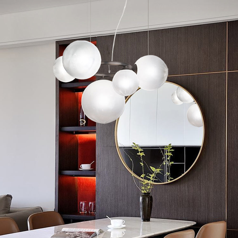 Hung beside a round gilt-framed mirror, a Clérachic ring-frame pendant carries 7 glowing opal glass globes.