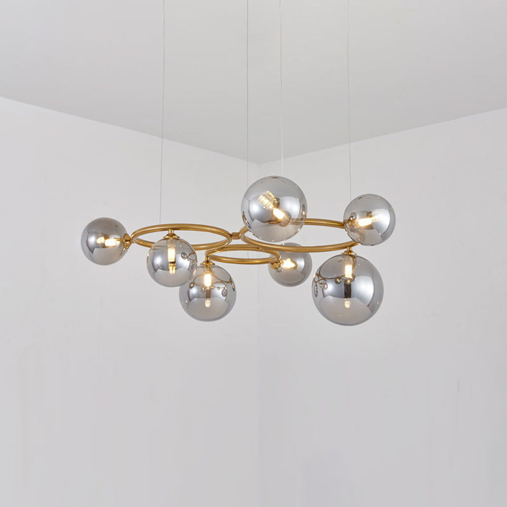 The brass Clérachic ring-frame pendant carries 7 smoked mirrored glass globes, photographed in a bright room.