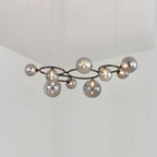 Nine smoked mirrored glass globes cluster around the black frame of this Clérachic pendant in a corner room.