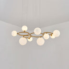 The brass Clérachic ring-frame pendant carries 9 glowing opal glass globes across its double ring frame.