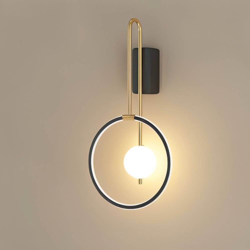 Clérachic black ring wall light with a brass-toned arm and a lit white glass ball, mounted on a plain warm taupe wall.