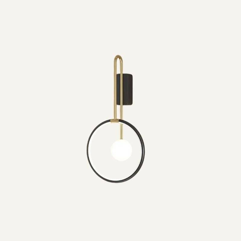 Clérachic black ring wall light with a brass-toned U-shaped arm and a glowing white glass ball, shown on an off-white ground.