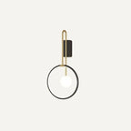 Clérachic black ring wall light with a brass-toned U-shaped arm and a glowing white glass ball, shown on an off-white ground.