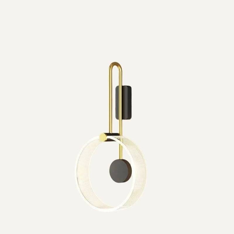Clérachic wall light with a clear fluted acrylic ring, black disc and brass-toned U-shaped arm, shown on an off-white ground.