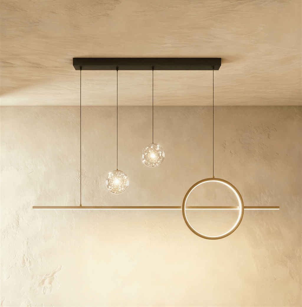 Clérachic gold ring and bar pendant light with two clear glass globes holding tiny sparkling lights, on limewash.
