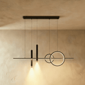 Clérachic black pendant light with a slim bar, two overlapping rings and two lit spot cylinders on a limewash wall.