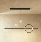 Clérachic black ring and bar pendant light with two clear glass globes holding tiny sparkling lights, on limewash.