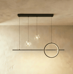 Clérachic black pendant light with a shorter bar, one ring and two clear sparkling glass globes on a limewash wall.