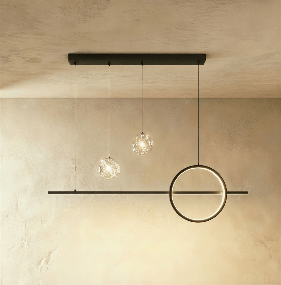 Clérachic black pendant light with a shorter bar, one ring and two clear sparkling glass globes on a limewash wall.