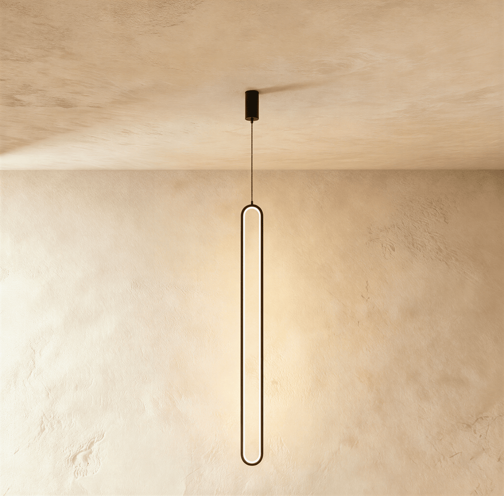 Clérachic slim black stadium-shaped LED loop pendant hanging long from a small black canopy against limewash.