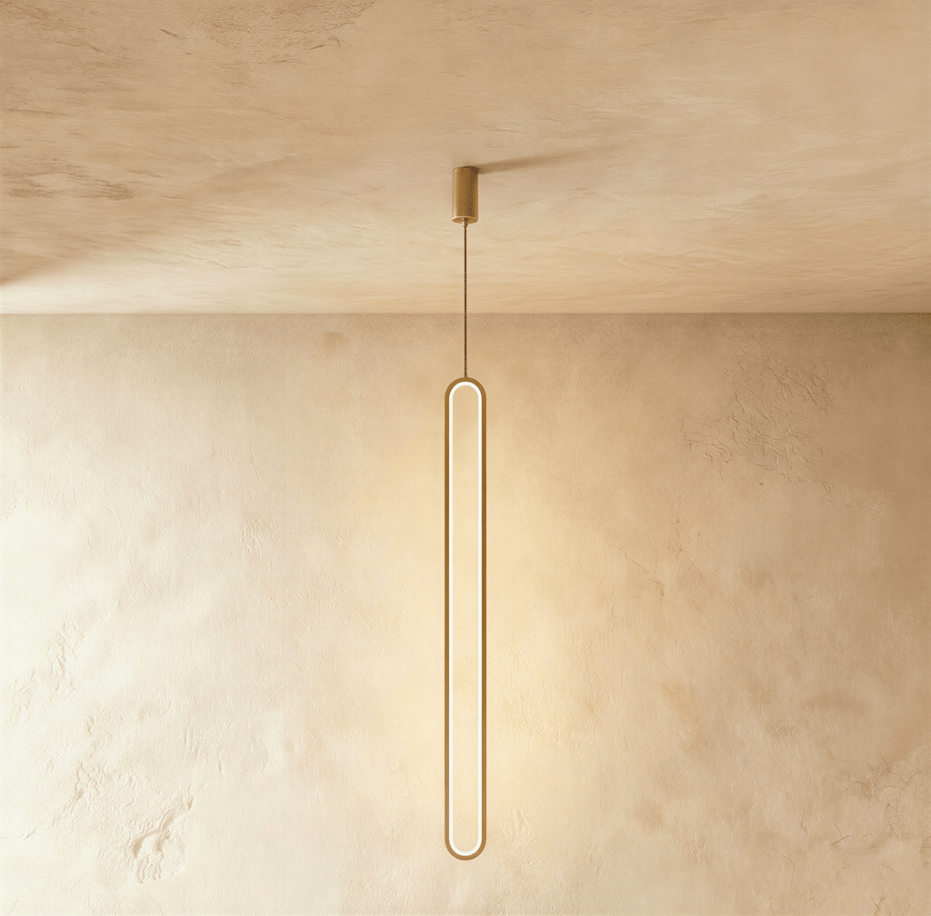 Clérachic slim gold stadium-shaped LED loop pendant hanging long from a small gold canopy against limewash.