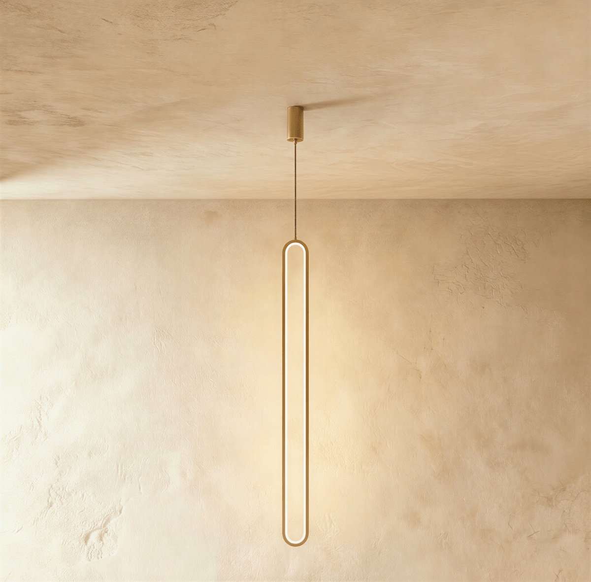 Clérachic slim gold stadium-shaped LED loop pendant hanging long from a small gold canopy against limewash.
