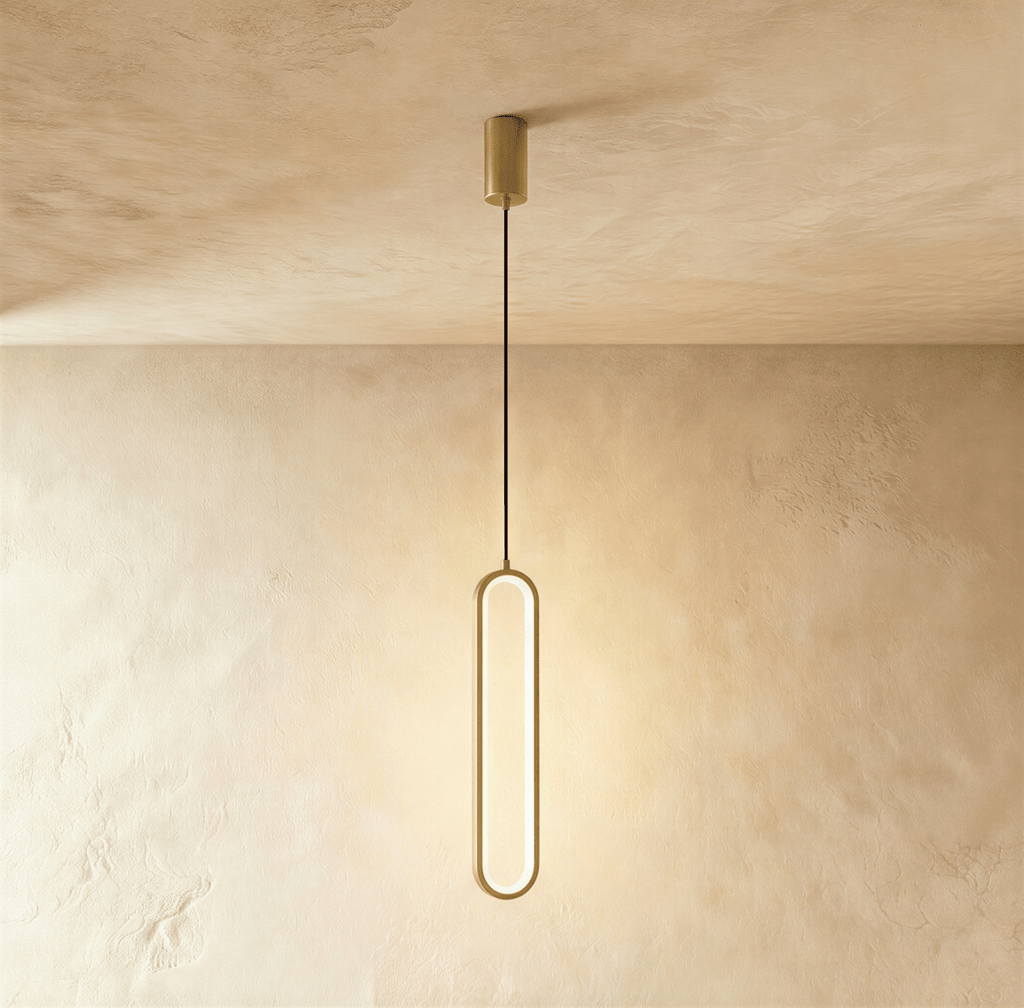 Clérachic compact gold stadium-shaped LED loop pendant on a short cord and round gold canopy, on a limewash wall.